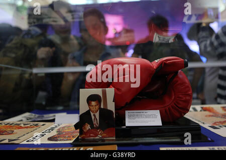 Quezon City, Arizona, USA. 3rd June, 2016. People look at a pair of boxing gloves signed by Muhammad Ali that he wore in the 'Thrilla in Manila' fight during an exhibit inside a mall in Quezon City, the Philippines, June 10, 2016. The exhibit showcased vintage photos, posters, and other memorabilia from the 1975, when Muhammad Ali versus Joe Frazier boxing fight dubbed 'Thrilla in Manila', to pay tribute to Ali who died in Phoenix, Arizona, at the age of 74 on June 3, 2016. © Rouelle Umali/Xinhua/Alamy Live News Stock Photo