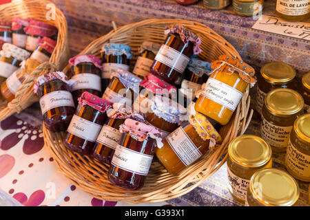 Basketfull of fruit jam jars on display at outdoor market, Lourmarin, Luberon, Vaucluse, Provence-Alpes-Côte d'Azur, France Stock Photo