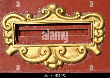 Mail slot on old red post box Stock Photo