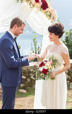 groom wears a wedding ring Stock Photo