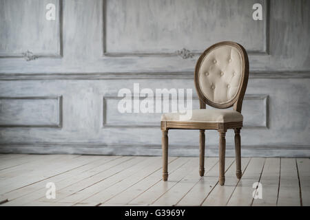 Living room with antique stylish light chair on luxury white wall design bas-relief stucco mouldings roccoco elements Stock Photo