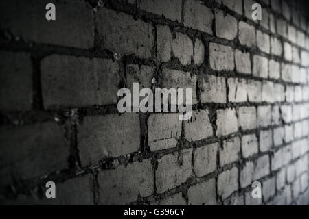 Side view on black brick wall lit by light from the window Stock Photo