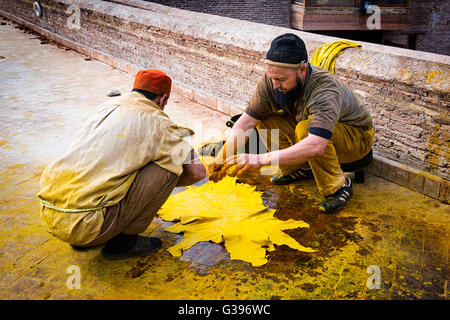 Fez, Morocco - April 11, 2016: Two man working in a tannery in the city of Fez in Morocco. Stock Photo