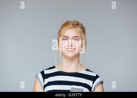 Portrait of cheeful pretty young woman in striped t-shirt over white background Stock Photo