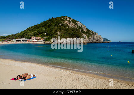 A Young Couple Sunbathing On The Beach At Paleokastritsa, Corfu Island, Greece Stock Photo