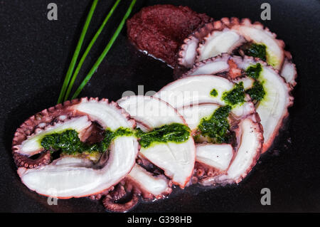 Octopus carpaccio on black dish Stock Photo