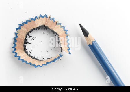 Close focus on sharp pencil and pencil shavings putting on white paper. Stock Photo