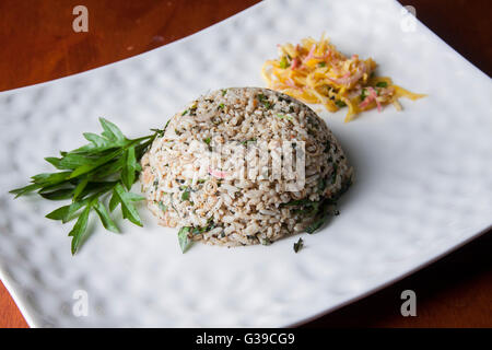 Nasi kerabu or herbed rice with condiments Stock Photo