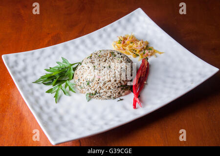 Nasi kerabu or herbed rice with condiments Stock Photo