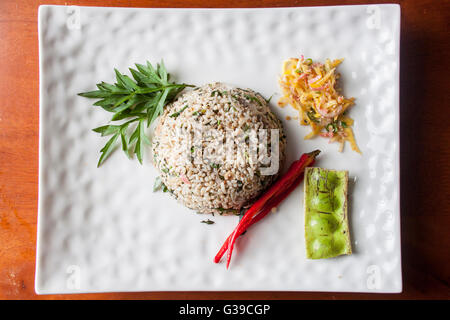 Nasi kerabu or herbed rice with condiments Stock Photo