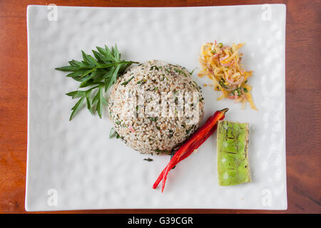 Nasi kerabu or herbed rice with condiments Stock Photo