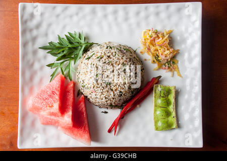 Nasi kerabu or herbed rice with condiments Stock Photo