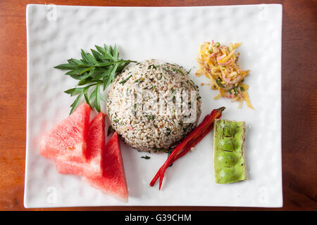 Nasi kerabu or herbed rice with condiments Stock Photo