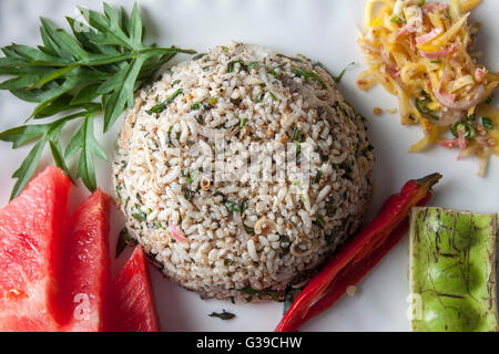 Nasi kerabu or herbed rice with condiments Stock Photo