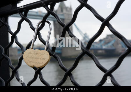 A single love lock on the railings in front of the Tower of London.  Tower Bridge in background. Stock Photo