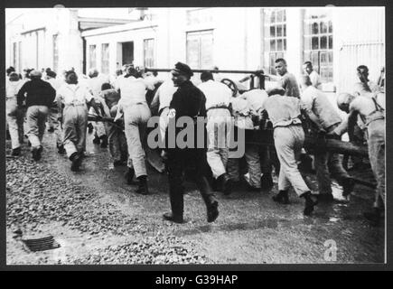 Forcing inmates to work in  Dachau Concentration Camp.        Date: 1933 Stock Photo