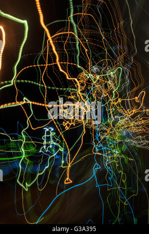 abstract curves traces of multi-colored trails of light on a dark background look like a spider web Stock Photo