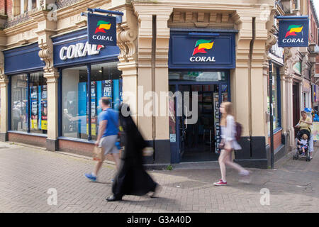 People passing Coral Bookmakers or bookmaker, sport, game, business, gambling, shopping, casino, business, gamble, money, entertainment, totalizator in Fishergate and Friargate in the Central Business District of the north western Lancashire town of Preston, UK Stock Photo