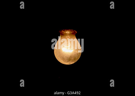 Old dusty bulb illuminated Stock Photo