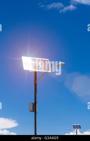 Solar panels on lamp posts using sunlight to generate electrical energy. Each light has a dedicated power generation unit. Stock Photo