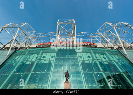 Old Trafford, the stadium of Manchester United Football Club, with the Sir Matt Busby statue on a sunny day (Editorial use only)
