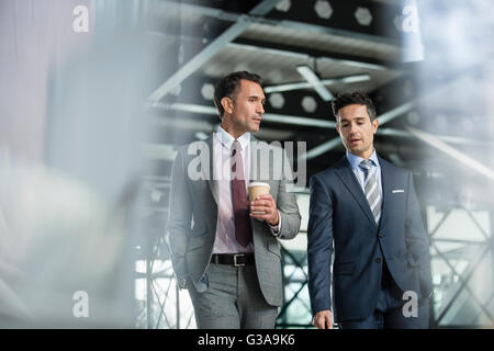 Corporate businessmen walking with coffee Stock Photo
