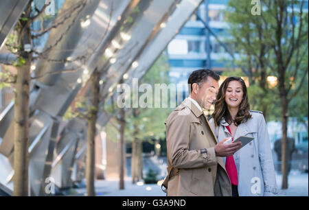Businessman and businesswoman using digital tablet in courtyard Stock Photo