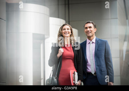 Smiling corporate businessman and businesswoman outside building Stock Photo