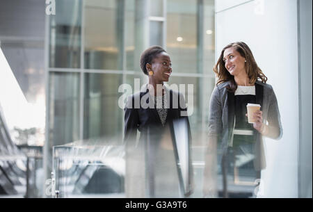 Corporate businesswomen with coffee talking and walking Stock Photo