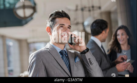 Smiling corporate businessman talking on cell phone Stock Photo