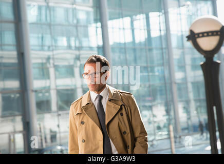 Corporate businessman in trench coat looking away Stock Photo