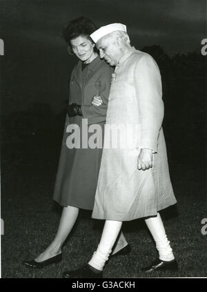 Mrs. Jacqueline Kennedy, wife of the President, John F. Kennedy, walks arm in arm with Prime Minister Jawaharwal Nehru of India, as they leave a helicopter and cross the lawn to the White House. Stock Photo