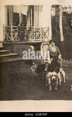 Woman with three dogs in the garden Stock Photo - Alamy