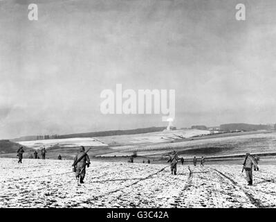 American soldiers advance across fields in the Bastogne area of the Ardennes, Belgium, during the Battle of the Bulge     Date: 1944 Stock Photo