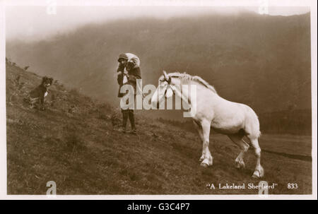 A shepherd of the Lakes with dog and leading his horse Stock Photo