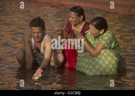 Man and women making a ritual offering (floating butter lamp) in river. Kumbh Mela 2016. Ujjain, Madhya Pradesh, India Stock Photo