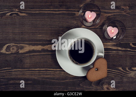 Coffee and cake in the shape of a heart on wooden planks Stock Photo