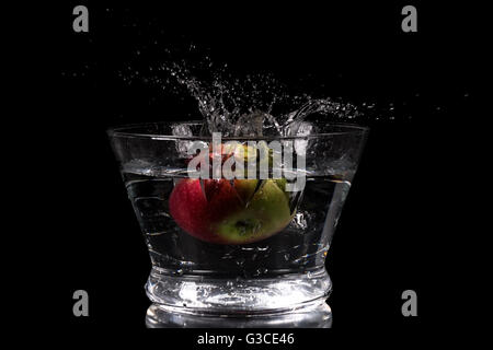 Apple splashing in water on a black background Stock Photo