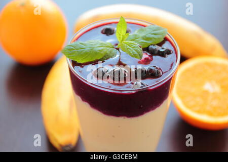Smoothie with banana, orange and blueberries fruits in a glass Stock Photo