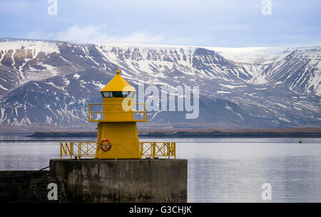 Yellow lighthouse in front of volcanoes, Reykjavik, Iceland Stock Photo