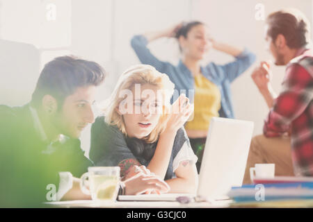 Creative young business people working at laptop in office Stock Photo