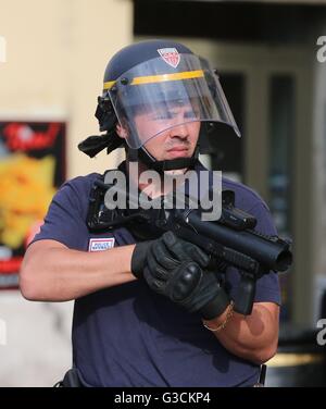 A French police officer holds a baton gun following clashes with English football fans outside The Queen Victoria pub in Marseille ahead of the first game in Euro 2016. Stock Photo