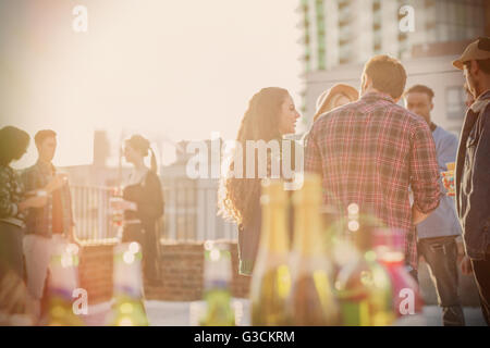 Young adult friends socializing at sunny rooftop party Stock Photo