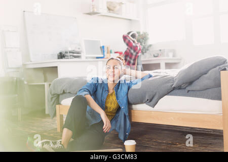 Female college student relaxing on bedroom floor Stock Photo