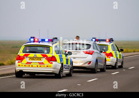 British Traffic policemen on Emergency 999 Response. British Police patrol cars attending vehicle traffic stop on Marine Drive, Southport promenade, Merseyside UK.  Two police vehicles were used in a pursuit tactic, as well as using red and blue lights to pull over the motorist speeding. Stock Photo