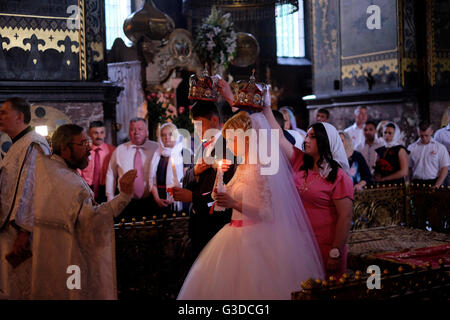 Ukrainian groom and bride are crowned during traditional crowning ceremony of an Eastern Orthodox Church wedding inside St Volodymyr's Cathedral in the centre of Kyiv or Kiev Ukraine Stock Photo