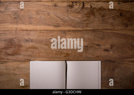 Book opened blank on dark wooden background with copyspace, top-view, closeup. Stock Photo