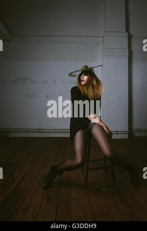 Woman with cymbal hat on chair Stock Photo