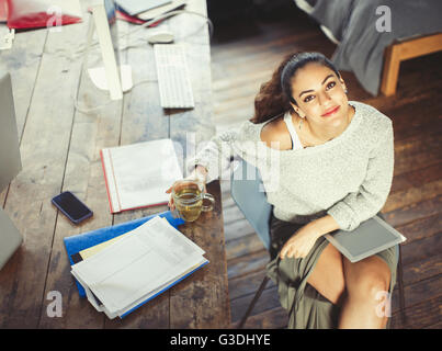 Portrait confident college student studying with tea and digital tablet Stock Photo