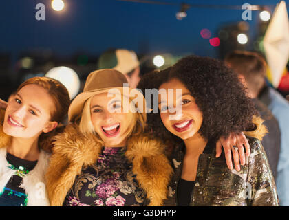 Portrait smiling young women enjoying rooftop party Stock Photo